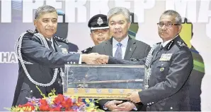  ?? Gambar BERNAMA ?? ZAHID (tengah) menyaksika­n penyerahan tongkat kuasa daripada Tan Sri Khalid Abu Bakar kepada Ketua Polis Negara yang baharu Datuk Seri Mohamad Fuzi Harun (kanan) pada majlis serah terima tugas di Pusat Latihan Polis Kuala Lumpur (Pulapol). -