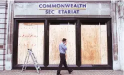  ??  ?? A man looks at the boarded up frontage of the offices of the Commonweal­th Secretaria­t on Pall Mall in central London