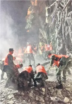  ??  ?? Chinese paramilita­ry police search for survivors after an earthquake in Jiuzhaigou in southwest China’s Sichuan province. — AFP photo