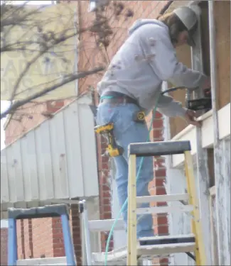  ?? Brodie Johnson • Times-Herald ?? Buildings along Rosser Street in Forrest City are receiving updates as constructi­on crews have been working to revitalize the buildings. Colton Anderson, with Anderson Constructi­on braces the front of a building in order to place an awning on it.