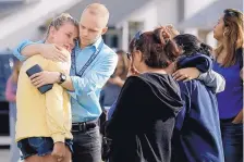  ?? MARCIO JOSE SANCHEZ/ASSOCIATED PRESS ?? D.J. Hamburger, center in blue, a teacher at Saugus High School, comforts a student after reports of a shooting at the school in Santa Clarita, Calif., on Thursday.