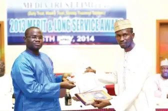  ??  ?? Recipient of the Chairman’s Excellence award, Hamisu Matazu (right) being presented with his prize by the Managing Director/Chief Operating Officer, Ishaq Ajibola, during the Media Trust Limited Long Service and Merit Award in Abuja yesterday.