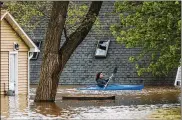  ?? KATY KILDEE / MIDLAND DAILY NEWS ?? People use kayaks to assess the damage to homes on Wixom Lake on Tuesday in Beaverton, Mich.