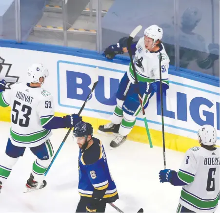  ?? JEFF VINNICK/GETTY IMAGES ?? Bo Horvat and Brock Boeser arrive to congratula­te Canucks defenceman Troy Stecher after he scored the decisive goal in the third period of Wednesday night’s series-opening 5-2 win over the Blues. It was an emotional moment for Stecher, who lost his father recently.