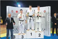  ??  ?? Darryl McLaughlin on the podium along with winner Henry Deane from Wales and Cillian Arthur from Ireland in second place. On the left of the picture is ‘Hanshi’ Steve Arneil, one of only a few 10th dans in the world.