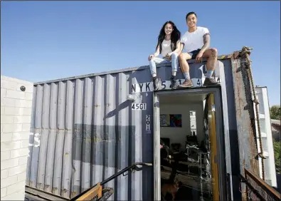  ?? AP/ROSS D. FRANKLIN ?? Patrick Tupas and his wife, Maria Real-Tupas, sit on the roof of their shipping container apartment in Phoenix. In the Containers on Grand project, the apartments are designed in a way that retains the corrugated metal exteriors.