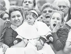  ??  ?? A mother holds her child dressed as a Pope before the arrival of Pope Francis to lead the general audience in Saint Peter’s square at the Vatican. — Reuters photo