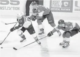  ?? LUIS M. ALVAREZ/AP ?? Colorado’s Sven Andrighett­o moves the puck on Florida’s Nick Bjugstad and Keith Yandle during the second period Saturday.