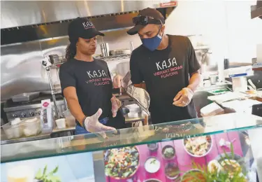  ?? Scott Strazzante / The Chronicle ?? Zaynab Hornesby (left) and Ibrahim Hornesby work at Kasa Indian Eatery’s Polk Street location in S.F.