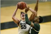  ?? CHARLIE NEIBERGALL — THE ASSOCIATED PRESS FILE ?? Iowa center Luka Garza (55) drives to the basket against Michigan State forward Marcus Bingham Jr., right, during the second half in Iowa City, Iowa, on Feb. 2. Garza was named The Associated Press men’s basketball player of the year on Thursday.