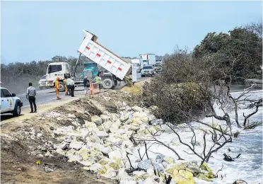  ?? ORLANDO AMADOR ?? Una volqueta arroja arena y piedras en el kilómetro 19 de la vía Barranquil­la - Ciénaga.