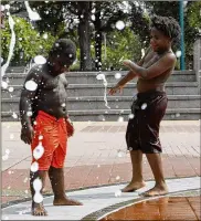  ?? ANDREA SMITH / ASSOCIATED PRESS ?? Kai Frazier and Chance Seawright, brothers visiting from Aiken, South Carolina, cool off while playing in the Fountain of Rings in Atlanta’s Centennial Olympic Park on Monday.