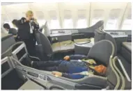  ?? Andy Cross, The Denver Post ?? Flight attendant Patty Johnson takes a picture of ramp serviceman Richard Fontanese as he reclines Thursday in 747 first class.