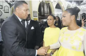  ?? (Photos: Naphtali Junior) ?? Prime Minister Andrew Holness greets Councillor Kari Douglas (Trafalgar division), daughter of the late Easton Doulas, during yesterday’s official funeral service at the St Andrew Parish Church, while her stepsister Rain Jarrett looks on.