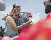  ?? John Locher Associated Press ?? CYNTHIA CHAVEZ, right, holds her daughter Mia Chavez on Sunday at the scene of the El Paso attack.