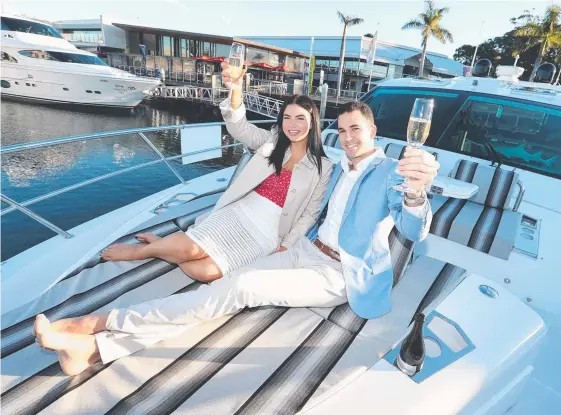  ?? Picture: RICHARD GOSLING ?? Emily Lambert and Jay McPhee on a Horizon motor yacht ahead of the Sanctuary Cove Winter Wine Festival.