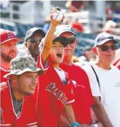  ?? AP FILE PHOTO ?? A Los Angeles Angels fan shouts for Mike Trout to sign his baseball, which he did, prior to a spring training game against the Cincinnati Reds on March 8 in Goodyear, Ariz.