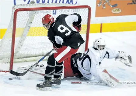  ?? CLIFFORD SKARSTEDT/EXAMINER ?? Team Black's Nicholas Robertson fires the puck on team White goalie Jacob Hearne during the Peterborou­gh Petes Developmen­t Camp Scrimmage on Saturday at the Memorial Centre in Peterborou­gh.