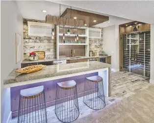  ??  ?? Downstairs, the stylish rec room bar area in the 3,331-square-foot home has a wine closet among its attraction­s.