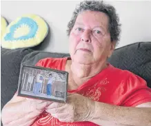  ?? ADAM MACINNIS • SALTWIRE NETWORK ?? Carol Phalen holds a picture of her son Ed with her husband, also named Ed. Her son was murdered 10 years ago but the killer has never been found.