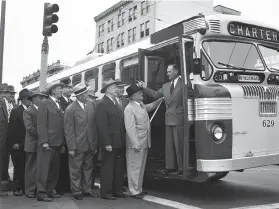  ?? Bob Campbell / The Chronicle 1949 ?? Passengers in suits and hats line up to board a special charter as the Municipal Railway rolled out electric buses on San Francisco’s Market Street in 1949.