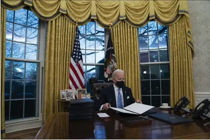  ?? EVAN VUCCI — THE ASSOCIATED PRESS FILE ?? President Joe Biden signs a series of executive orders in the Oval Office of the White House in Washington.