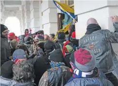  ?? AP PHOTO/JOSE LUIS MAGANA ?? Insurrecti­onists loyal to President Donald Trump try to open a door of the U.S. Capitol as they riot in Washington on Jan. 6.