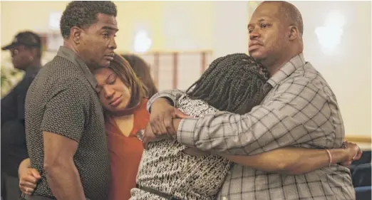  ?? ASHLEE REZIN/ SUN- TIMES ?? Robert Hood ( right) hugs his aunt after the funeral services for 17- year- old China Marie Lyons- Upshaw at Leak & Sons Funeral Homes, Wednesday.