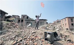  ?? A Nepalese boy flies a kite while standing on the rubble of houses that collapsed in the April 25 earthquake in Bhaktapur, Nepal. The quake topped Google searches in the internatio­nal news category.
AP ??