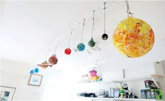  ??  ?? A ceiling art installati­on in the playroom for the couple’s three children.