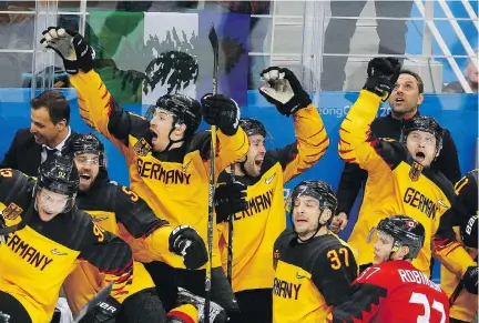  ?? LEAH HENNEL ?? Canadian defenceman Mat Robinson of Calgary gets a front-seat view of the enthusiast­ic German celebratio­n after the underdogs defeated Canada 4-3 in their semifinal match to advance to the gold-medal game against the Olympic Athletes from Russia.