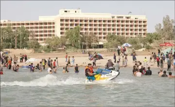  ??  ?? In this file photo taken on June 17, 2012, Iraqis swim and ride jetskis in Lake Habbaniyah.
