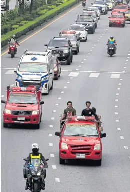  ?? PORNPROM SATRABHAYA ?? A convoy of vehicles takes the body of Kornsith Laophan, 19, a rescue worker killed in the fire for royally sponsored funeral rites in Thung Kru district.