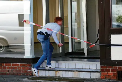  ?? FOTO: CHRISTOPHE GATEAU/DPA ?? Ein Polizist am Tatort: In diesem Haus in Niedersach­sen haben Ermittler zwei Leichen gefunden.