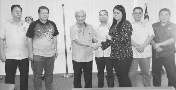  ??  ?? Masing presents a cheque to a recipient during the MRP fund-presentati­on ceremony on Saturday. Ugak is at second left.