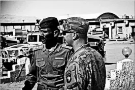  ?? 1ST LT. DANIEL JOHNSON/U.S. ARMY ?? Army Capt. Gerrard Spinney confers with his Iraqi counterpar­t this month before a meeting at Camp Swift in Iraq. The groups that make up Iraq’s forces are converging on Mosul.