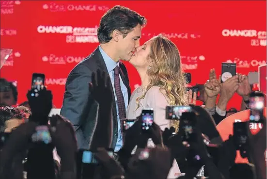 ?? NICHOLAS KAMM / AFP ?? El liberal Justin Trudeau besa a su esposa, Sophie, al llegar a Montreal después de ganar las elecciones