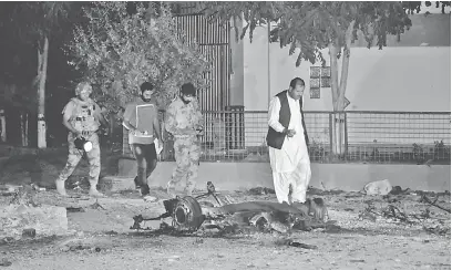  ?? — Gambar Reuters ?? PERIKSA: Pegawai keselamata­n dan anggota separa tentera memeriksa lokasi di mana lima pengebom nekad cuba memandu sebuah van sarat dengan amunisi dan bahan letupan ke kemudahan tentera di Quetta, Pakistan kelmarin.