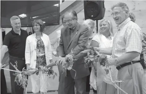  ?? [WHITNEY NEILSON / THE OBSERVER] ?? MPP Michael Harris, Mayor Sandy Shantz, Minister of Agricultur­e, Food, and Rural Affairs Jeff Leal, and Waterloo Region Chair Ken Seiling cut the burlap garland to officially open the St. Jacobs Farmers’ Market’s newest building on Sept. 1.