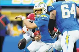  ?? ASHLEY LANDIS AP ?? Chargers QB Easton Stick fumbles the ball as he is sacked by Charles Omenihu.