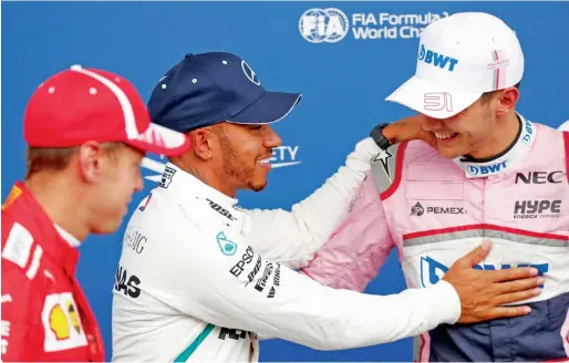  ?? Reuters ?? Mercedes’ Lewis Hamilton celebrates qualifying in pole position with Force India’s Esteban Ocon (right) who qualified in third position. —