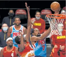  ?? Sarah Stier, Getty Images ?? The Brooklyn Nets’ Kevin Durant puts up a shot as Denver’s Bol Bol (10) and Paul Millsap (4) trail the play during the second half on Tuesday night.