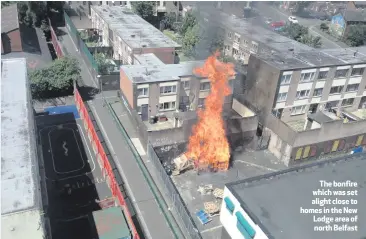  ??  ?? The bonfire whichwasse­t alight close to homes in the New Lodge area of north Belfast