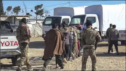  ??  ?? صورة عن شريط فيديو أطلقته «وحدات حماية الشعب» الكردية يصور عناصر من قواتها يسوقون رجالا من مخيم الهول إلى شاحنات أمس