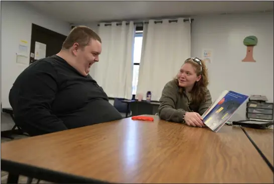  ?? PHOTOS BY HYOUNG CHANG — THE DENVER POST ?? Ethan Ortengren, 16, laughs while reading a book with registered behavior technician Sadie Kearns at Seven Dimensions Behavioral Health in Evergreen on Wednesday.