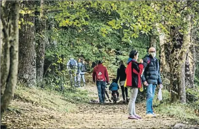  ?? LLIBERT TEIXIDÓ ?? Excursioni­stas de todas las edades caminan alrededor del pantano de Santa Fe del Montseny