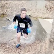  ?? Keith Bryant/The Weekly Vista ?? Bentonvill­e resident Joab Nazario sprints across a creek during the 5k trail run early Saturday morning.