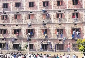  ?? AFP FILE ?? In this widely circulated picture from Uttar Pradesh’s neighbouri­ng Bihar, people climbed the walls of a school to help students cheat in an exam. The image became symbolic of the cheating menace that plagues large parts of the country.