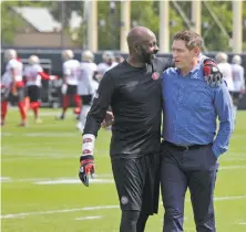  ?? Lea Suzuki / The Chronicle ?? Former 49ers receiving great Jerry Rice (left) and quarterbac­k Steve Young greet each other during team practice. The Hall of Famers hope to help impart a winning attitude.