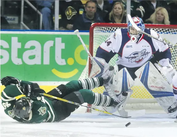  ?? MIKE HENSEN ?? The London Knights’ Max Jones tries to sweep the puck at Windsor Spitfires goaltender Mikey DiPietro after being tripped up during the first period of Game 5 of their Western Conference quarter-final series Friday night at Budweiser Gardens in London....